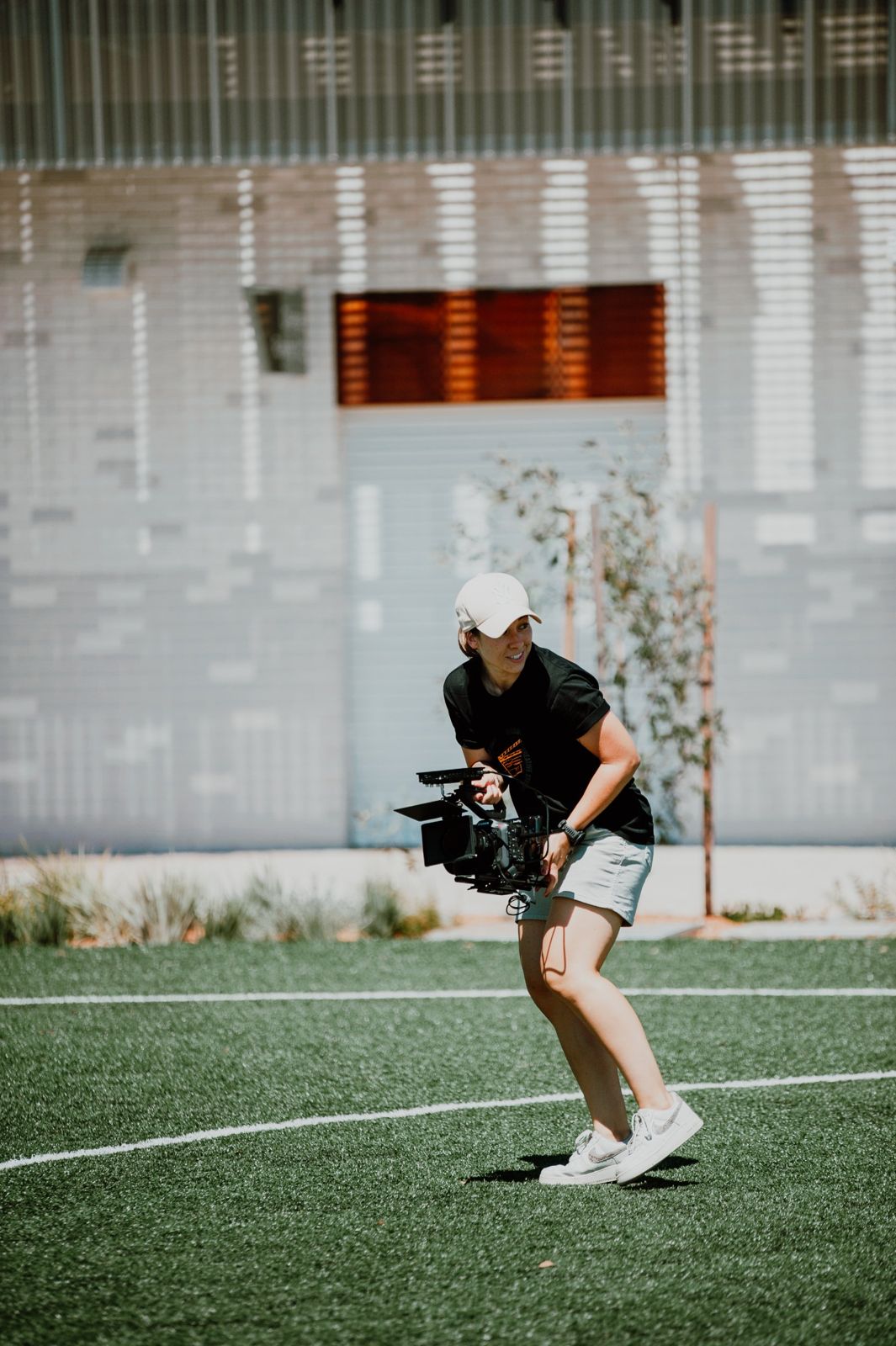 Kelly operating a handheld cinema camera outdoors